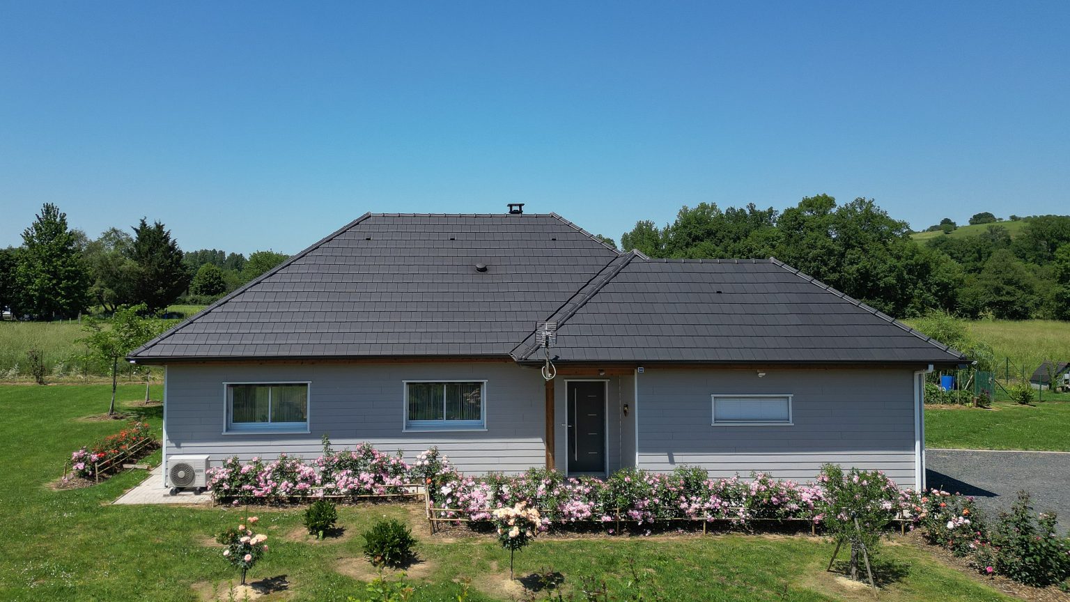 Façade principale d'une maison ossature bois avec garage attenant