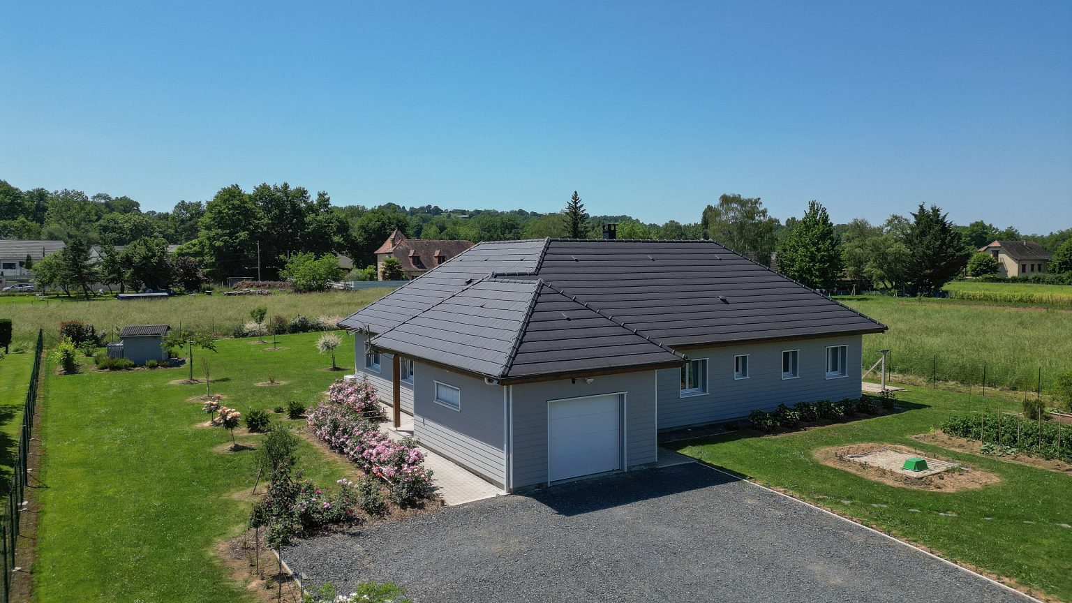Maison ossature bois avec garage attenant et toiture en tuiles noires