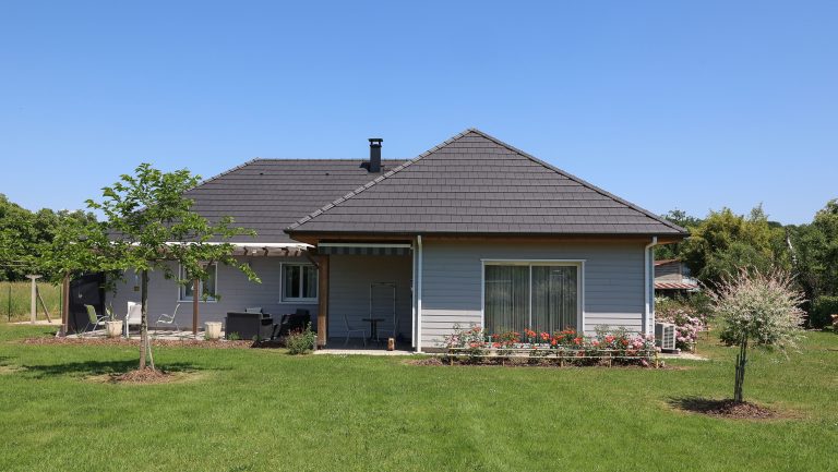 Terrasse béton avec pergola bois d'une maison ossature bois