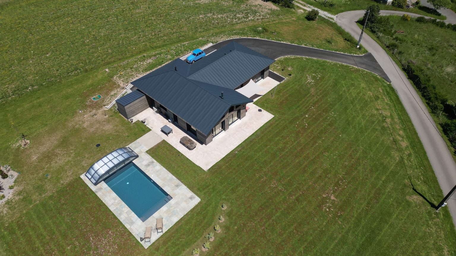 Vue aérienne d'une maison ossature bois avec carport et piscine en Corrèze