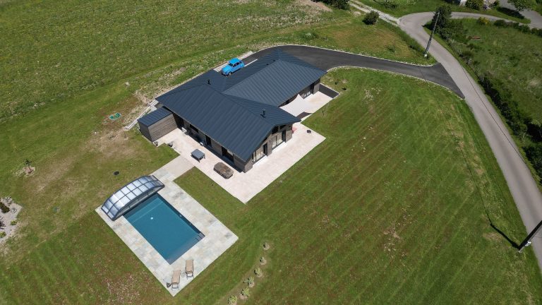 Vue aérienne d'une maison ossature bois avec carport et piscine en Corrèze