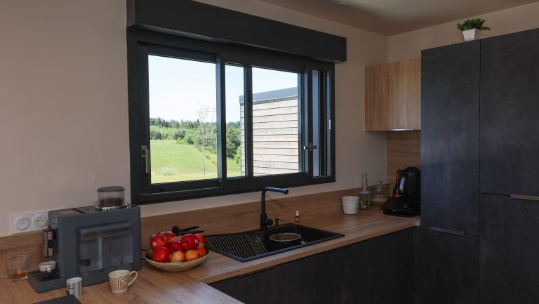Cuisine avec menuiseries extérieures aluminium dans une maison ossature bois